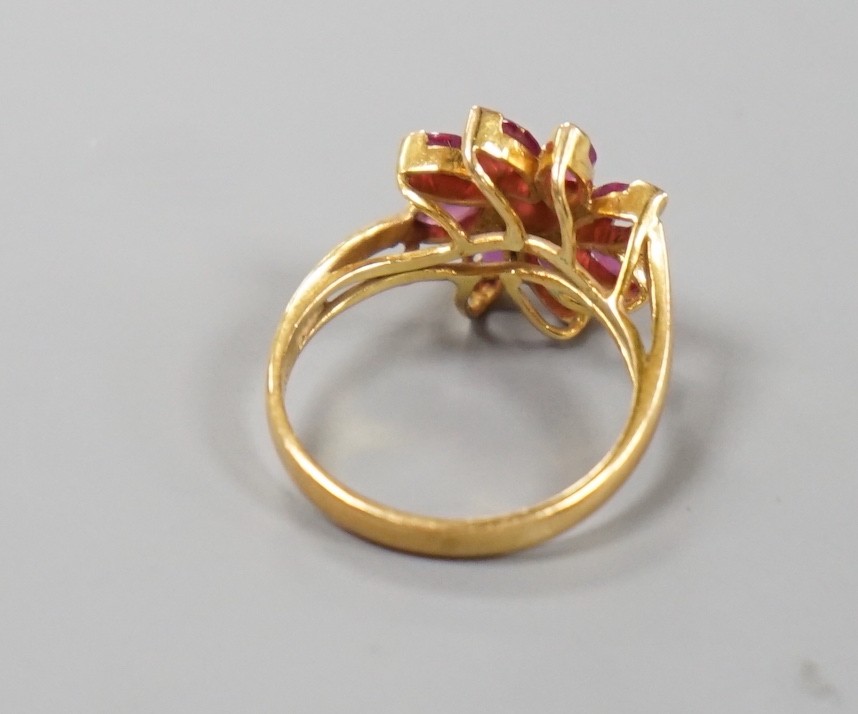 A continental yellow metal and ruby cluster set ring, size K, gross weight 3.1 grams.